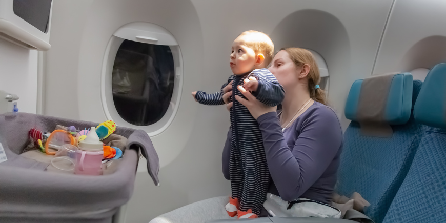 Baby standing up in front of the baby cradle