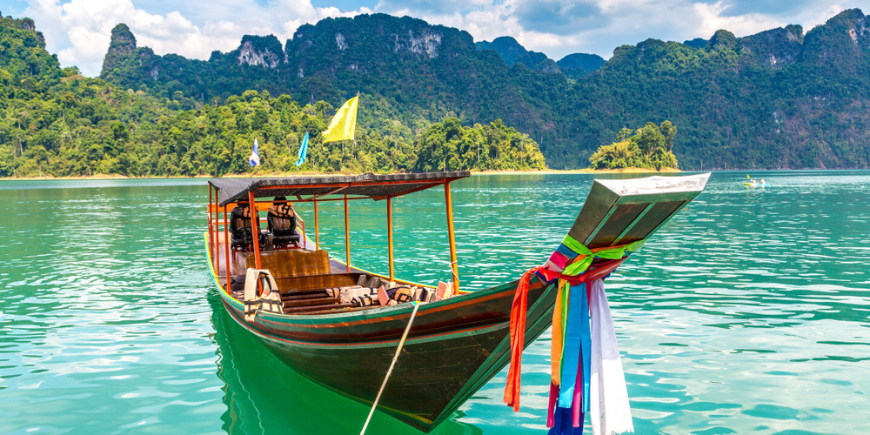 Traditional longtail boat with beautiful scenery view in Ratchaprapha Dam at Khao Sok National Park, Surat Thani Province, Thailand.