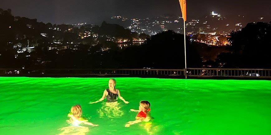 Children swimming in pool overlooking Kandy