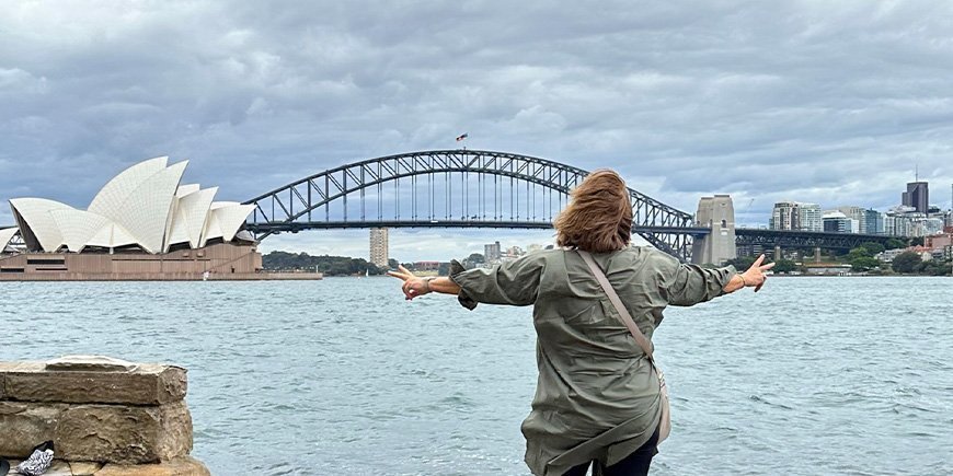 Beate standing in front of the Opera House and Sydney Harbour Bridge in Australia