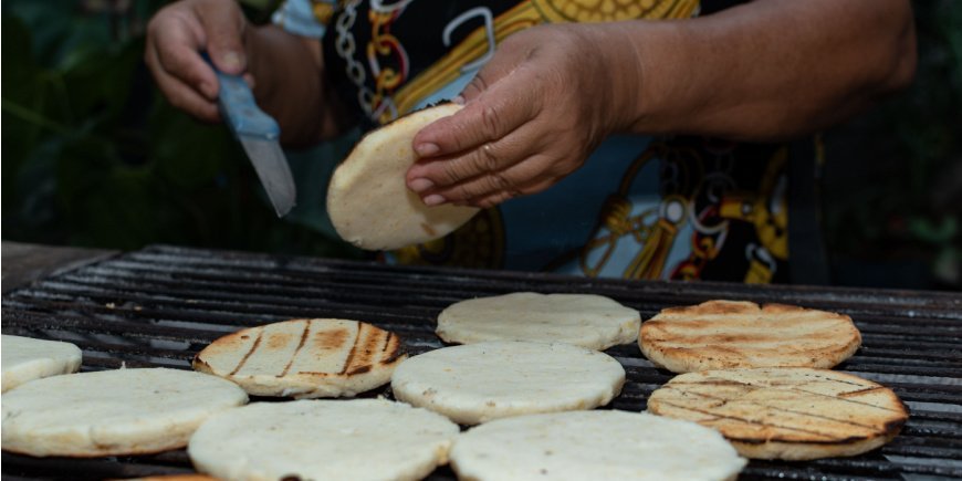 Person preparing arepa on the grill