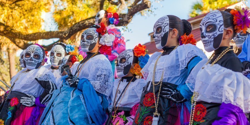 Women in colourful costumes with decorated skulls for Day of the Dead in Mexico