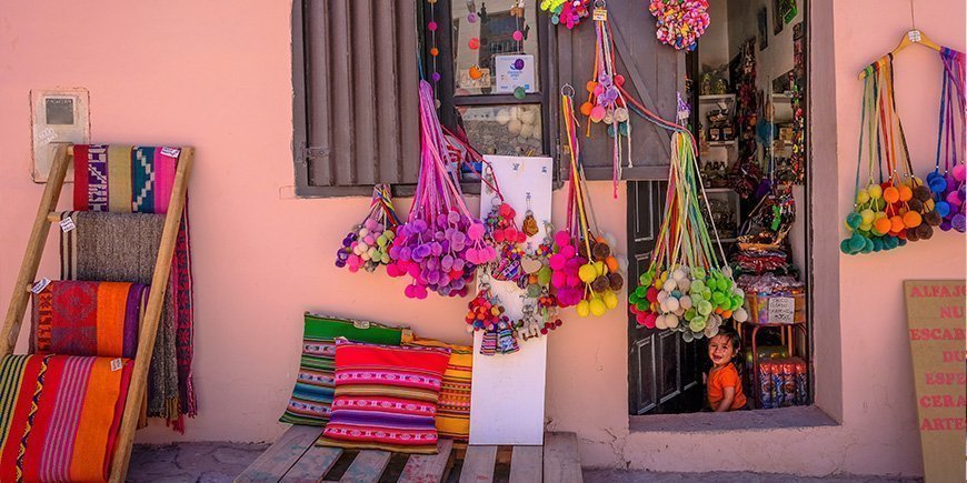 Small local shop in Purmamarca, Argentina and a girl sitting in the doorway.