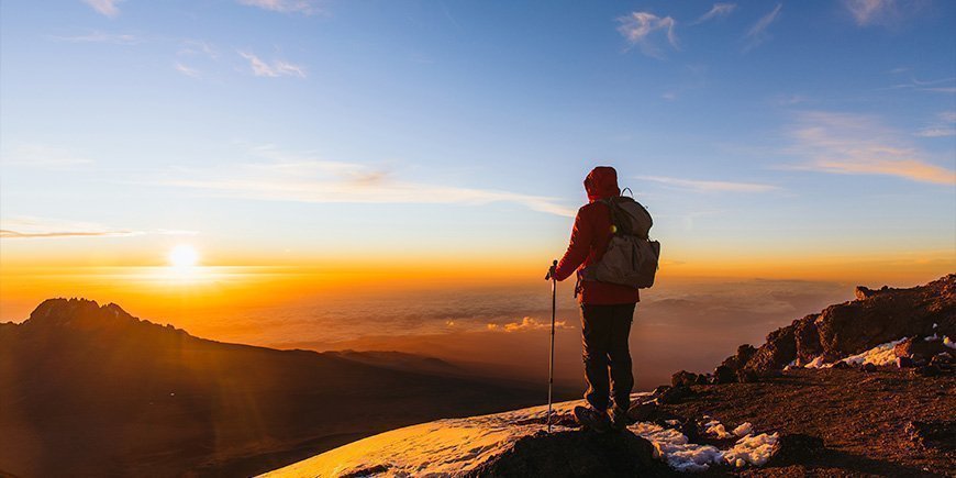 Man stands on Kilimanjaro at sunrise