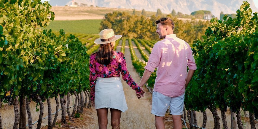 Woman and man holding hands in a vineyard in South Africa