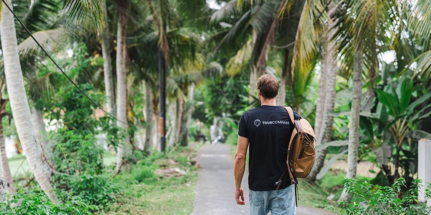 Man walks under palm trees in Bali, Indonesia