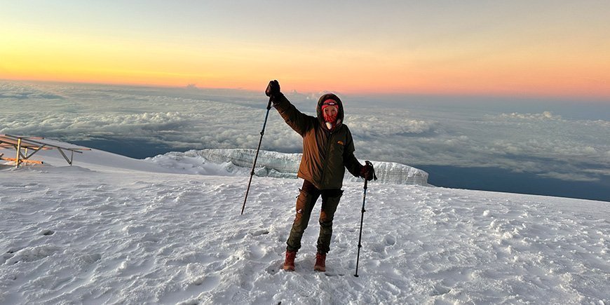 Woman standing in the snow on top of Kilimanjaro.