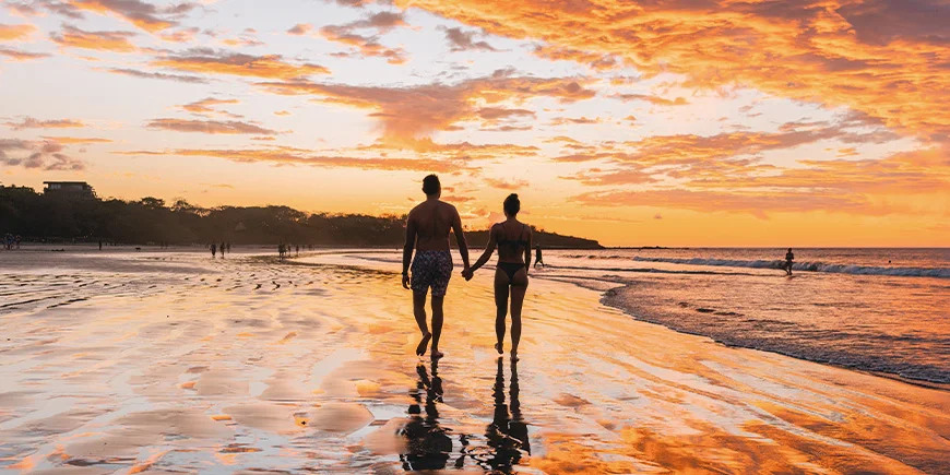 Man and woman walking on Tamarindo Beach in Costa Rica