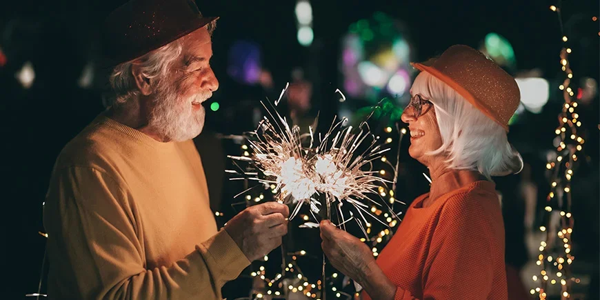 Elderly couple celebrating New Year with sparklers