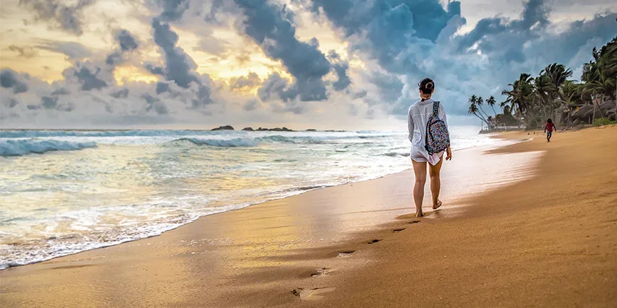 Woman walking on the beach in Sri Lanka