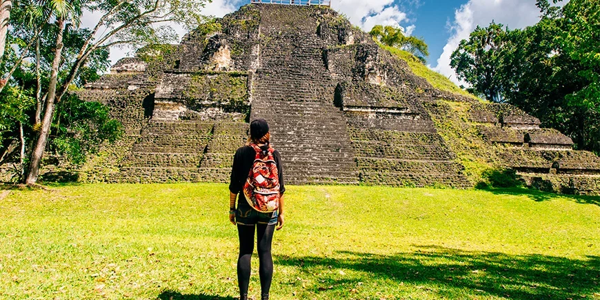 Woman standing in front of a pyramid in Tikal National Park 
