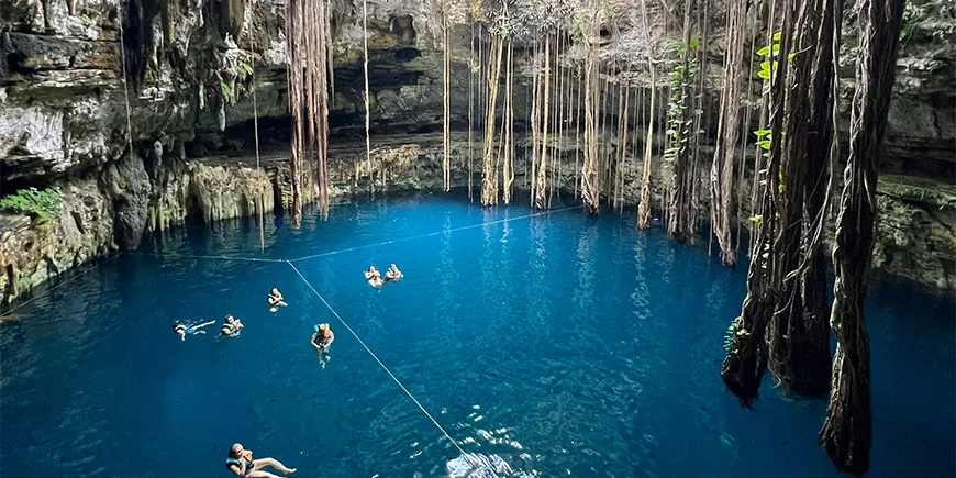 Group of people swimming in the beautiful Oxman cenote in Mexico
