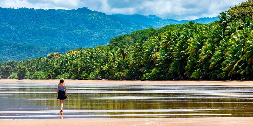 Woman walking by the water on Manuel Antonio Beach in Costa Rica