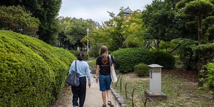 Japanese guide walking with a TourCompass employee by Osaka Castle in Japan