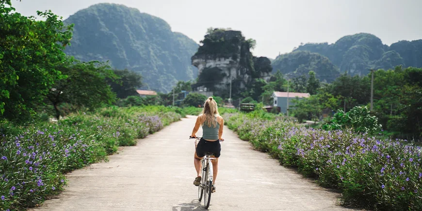 Woman cycling along a quiet road in Ninh Binh, Vietnam