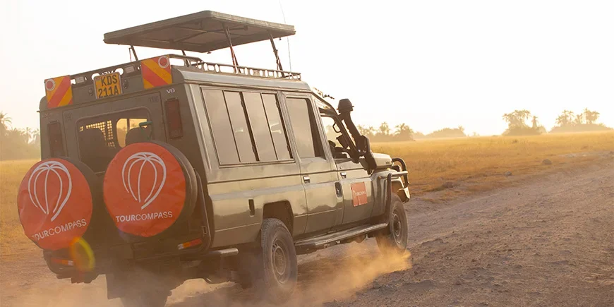 Jeep with TourCompass logo driving across the savannah in Kenya