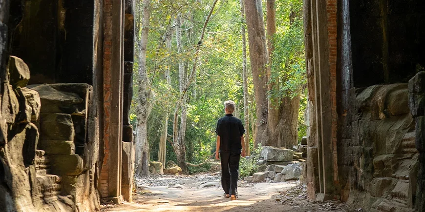 Man walking through ruins in Cambodia