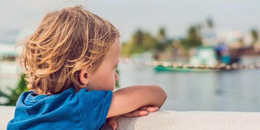 Boy looking at boats in the water at Phu Quoc, Vietnam