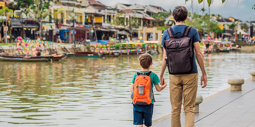 Father and son walk hand in hand in Hoi An