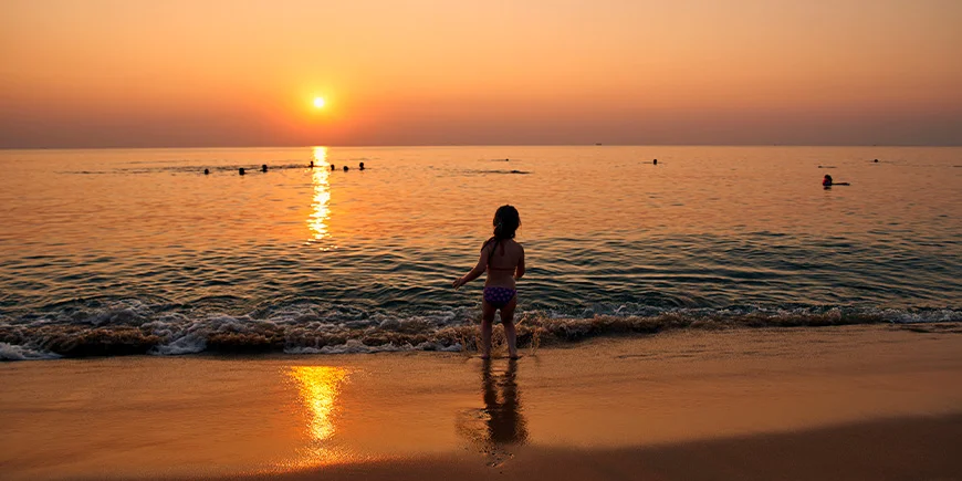 A girl playing in the water on Phu Quoc at sunset