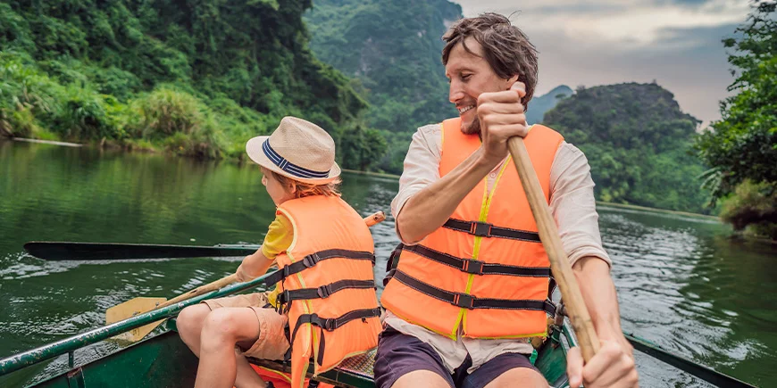 Father and son sailing in Ninh Binh in Vietnam