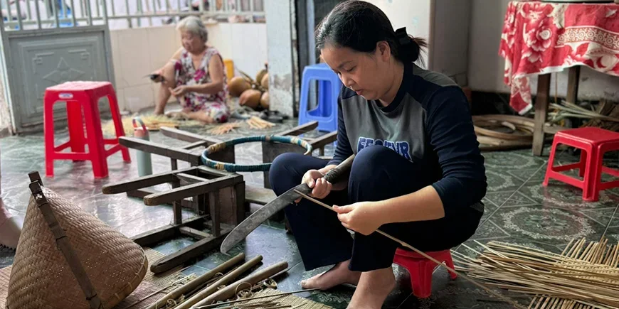Vietnamese woman crafting items from coconuts