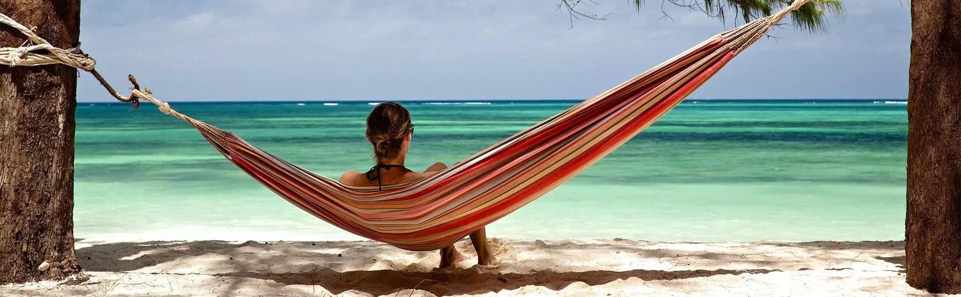 Woman lying in a hammock on a beach in Zanzibar