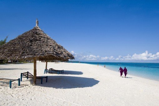 Locals walking at the water’s edge in Zanzibar