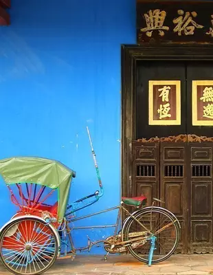 Old rickshaw next to a beautiful Chinese door in Georgetown, Malaysia