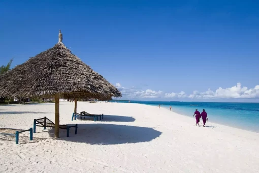 Locals walking at the water’s edge in Zanzibar