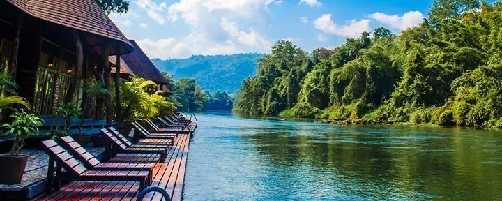 Lounge chairs surrounded by lush greenery on the River Kwai.