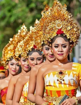 Group of Balinese people. Beautiful dancers in traditional costume dancing in a street parade at an art and culture festival.